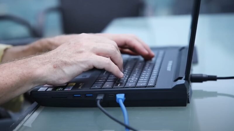 Close-Up of A Person's Hands Typing on A Mantis Computer, Which Is Equipped for Real-Time Video Encoding and Display