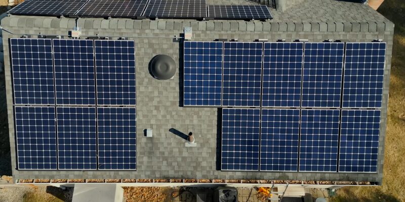 Aerial View of A House Roof Equipped with Multiple Solar Panels, Showcasing a Sustainable Energy Setup