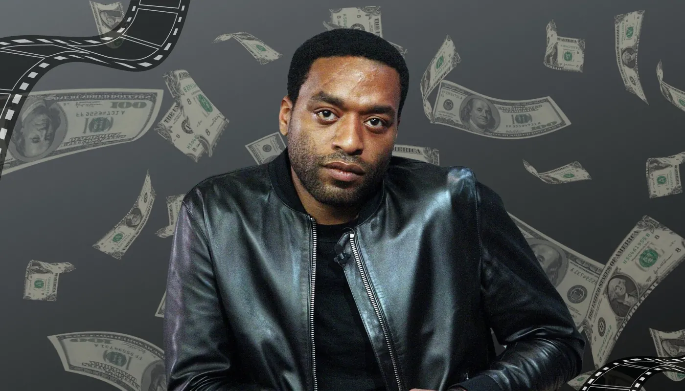 Chiwetel Ejiofor wearing a black leather jacket with dollar bills and film reel graphics in the background