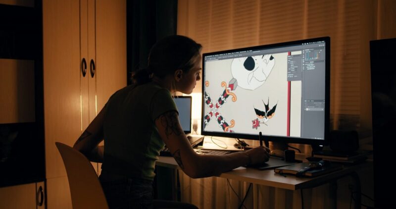 Woman creating digital illustrations on a graphic tablet for art licensing opportunities