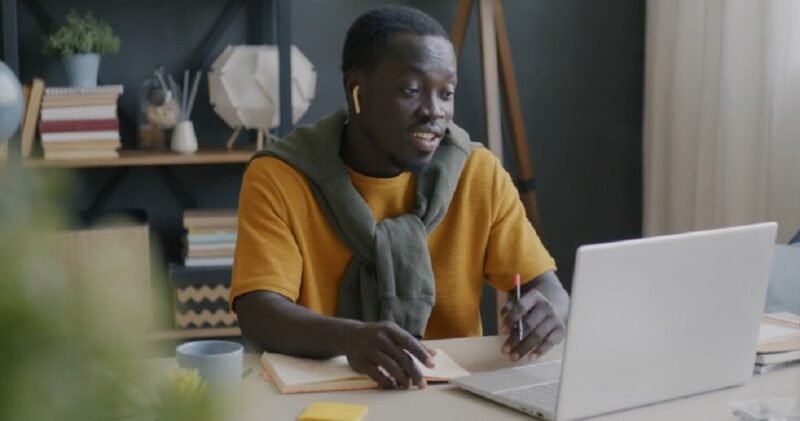 Man hosting a virtual lesson via laptop, teaching students online from home