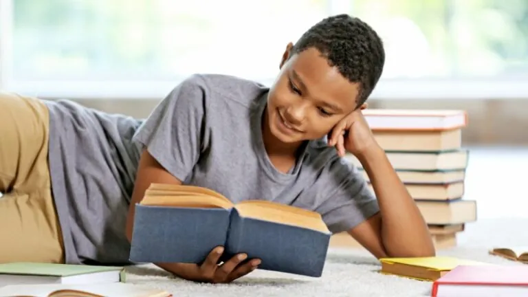 A young boy reads a book while surrounded by others, learning about climate change through engaging stories