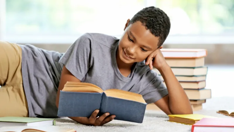 A young boy reads a book while surrounded by others, learning about climate change through engaging stories