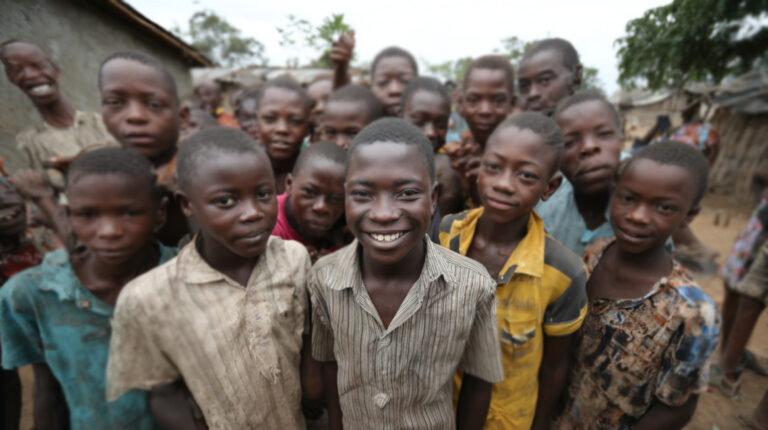 Group of smiling African children standing in a rural village