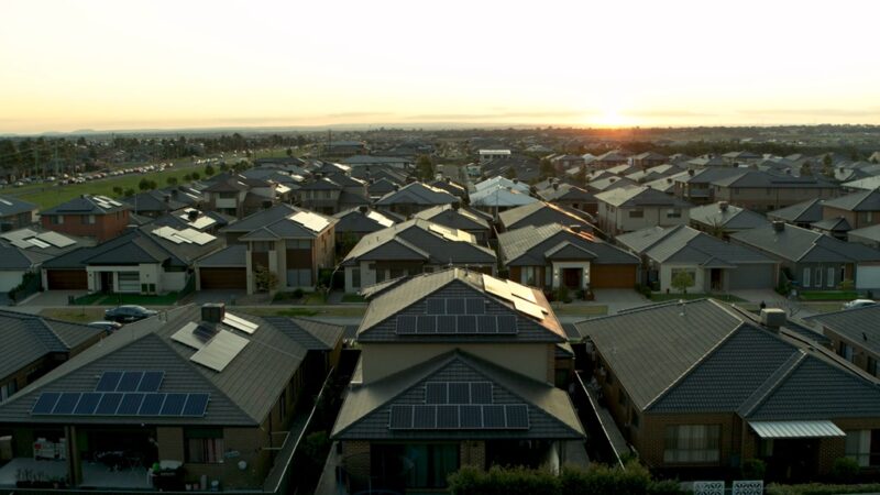 Aerial view of suburban neighborhood with many homes featuring rooftop solar panels