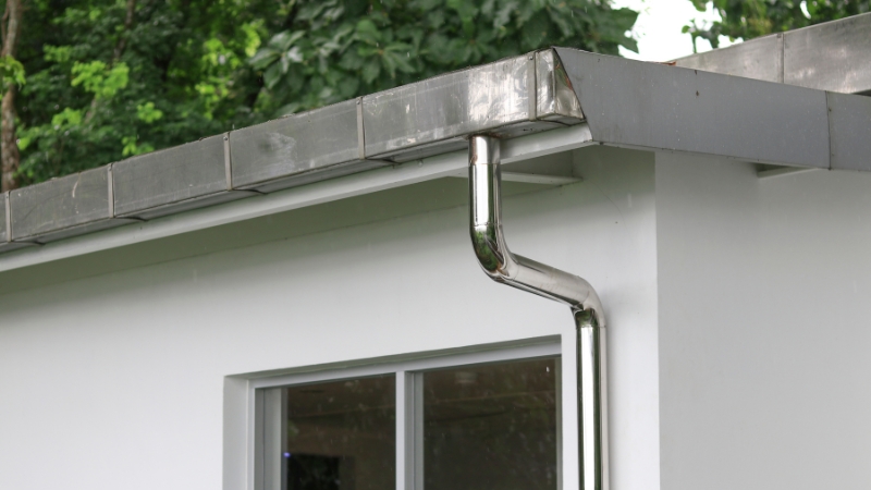 Roof drainage system connected to a modern house wall designed for efficient roof drainage and rainwater storage