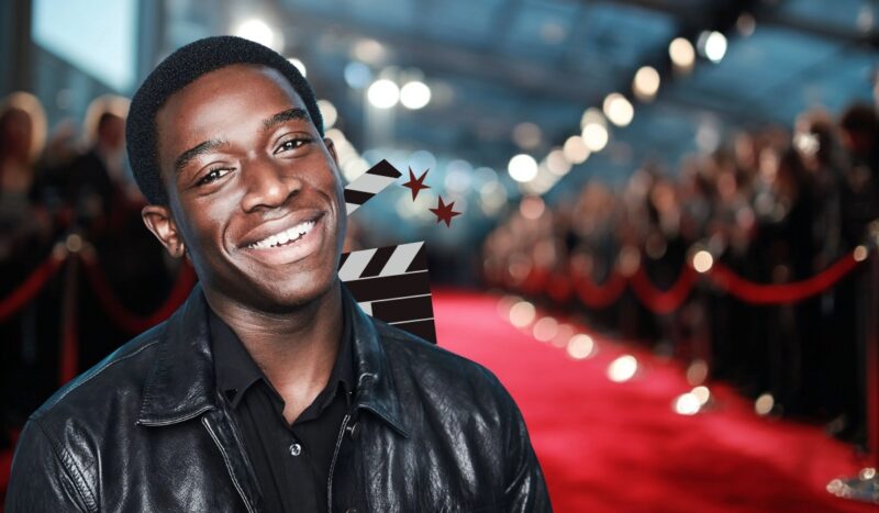 Actor Damson Idris smiling on the red carpet in a leather jacket