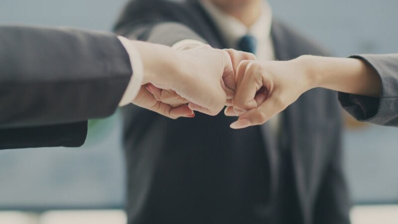 Business team performing a fist bump to represent trust, teamwork, and brand authenticity