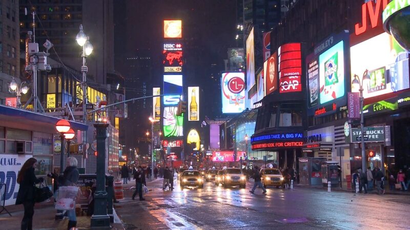 City at night with bright brand billboards symbolizing market dominance of large corporations