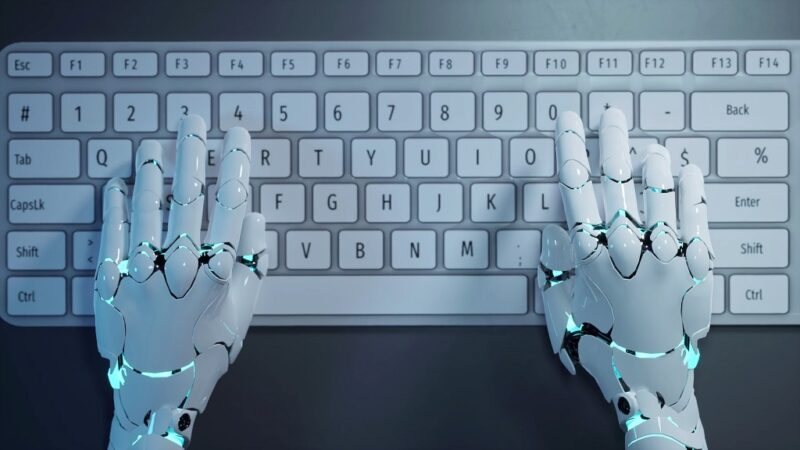 Robotic hands typing on a keyboard, symbolizing automation and AI use in small business operations