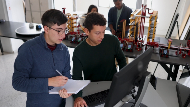 Two engineering students review a project on a computer in a lab for advanced engineering education