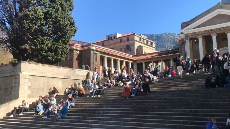 Students sitting on the iconic upper campus steps at the University of Cape Town with mountain views in the background