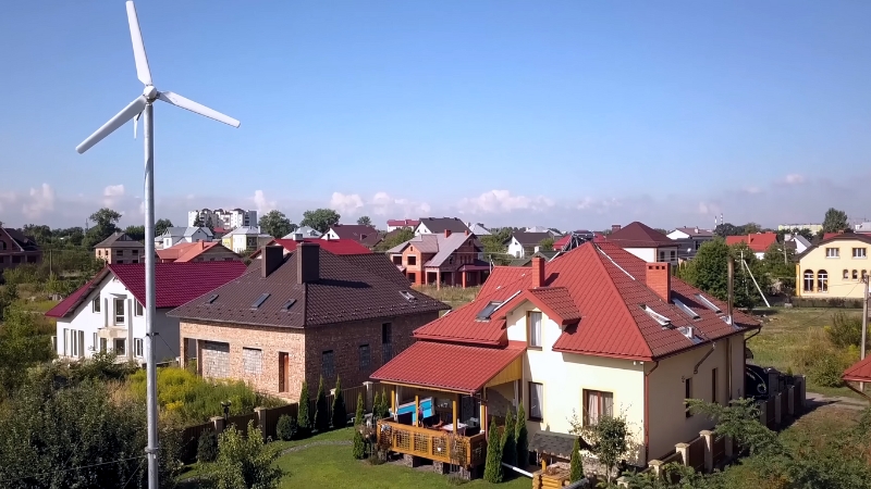 Small residential wind turbine installed near houses in a suburban neighborhood