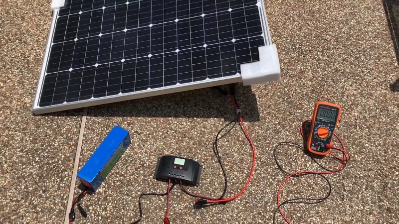 LiFePO4 battery connected to a solar panel, charge controller, and multimeter during a solar system setup