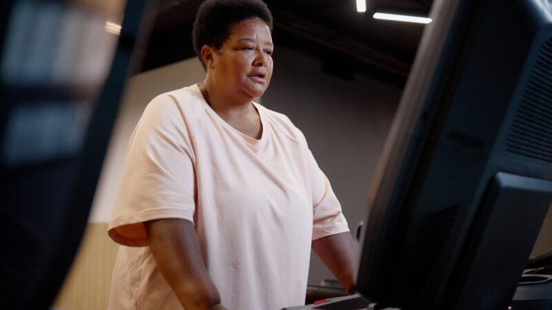 Gym member checks a workout display during a treadmill session